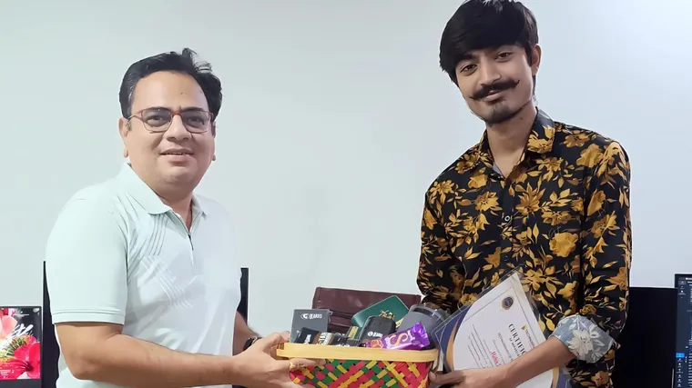A TechnoBrains team member receiving an award hamper and certificate in the office